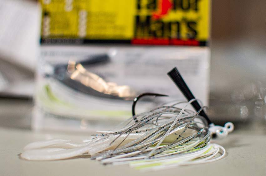 A Taylor Man's Swim Jig lays on a table, the package blurred but in the background